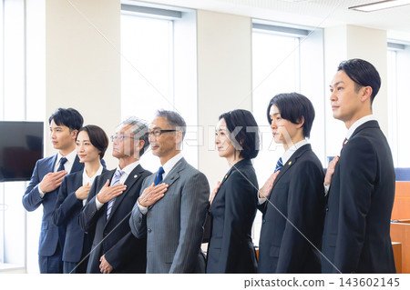 Seven lawyers, two men and two women, stand in a line with their hands on their chests. Seven lawyers, two men and two women, stand in a line with their hands on their chests. 143602145