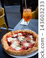 Delicious Neapolitan Pizza and Refreshing Aperol Spritz Cocktail on a Sunny Terrace 143603233