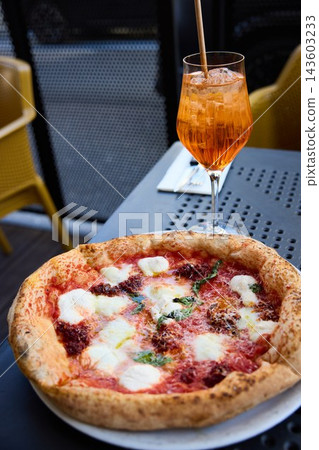 Delicious Neapolitan Pizza and Refreshing Aperol Spritz Cocktail on a Sunny Terrace Delicious Neapolitan Pizza and Refreshing Aperol Spritz Cocktail on a Sunny Terrace 143603233