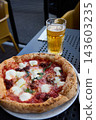 Delicious Neapolitan Pizza and Cold Beer on a Sunny Outdoor Terrace Table 143603235
