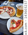 Delicious Neapolitan Pizza and Cold Beer on a Sunny Outdoor Terrace Table 143603237