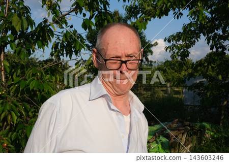 Senior man showing exaggerated surprise near cherry tree and blue sky with expressive gestures and humorous reaction Senior man showing exaggerated surprise near cherry tree and blue sky with expressive gestures and humorous reaction 143603246