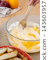 Cooking process. Pastry recipe. Woman chef hand stirring with spoon cream egg yellow liquid dough preparing fruit dessert on kitchen table. 143603957