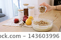 Cooking dough. Preparing pastry. Female baker hand pouring chopped walnut to glass bowl with culinary liquid mass making tasty treat. 143603996