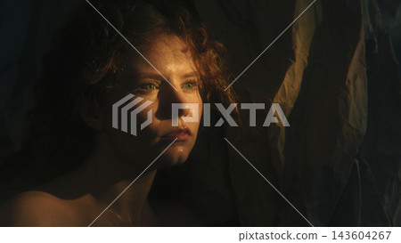 Introspective Woman Expressing Emotional Vulnerability in Dramatic Warm Light Introspective Woman Expressing Emotional Vulnerability in Dramatic Warm Light 143604267