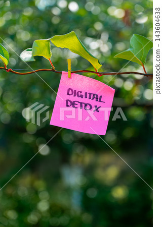 Paper note reading DIGITAL DETOX attached to leafy green plant. Suitable for digital detox, screen-free lifestyle technology Paper note reading DIGITAL DETOX attached to leafy green plant. Suitable for digital detox, screen-free lifestyle technology 143604638