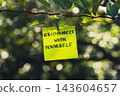 Paper note with RECONNECT WITH YOURSELF message against green leafy background. Suitable for digital detox, screen-free lifestyle technology break mindfulness. 143604657