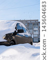 Cars Almost Completely Buried Under Thick Snowdrifts in Winter. Parked cars covered with thick layers of snow resemble large snowdrifts after heavy winter snowfall 143604683