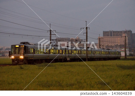 一列由 4 節車廂組成的 223 系列 6000 系列當地列車正在 JR 寶塚線上運行。 143604839