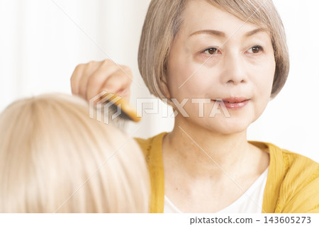 有些老年婦女因為擔心頭髮稀疏而戴假髮。 有些老年婦女因為擔心頭髮稀疏而戴假髮。 143605273