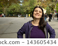 Outdoors lifestyle of a smiling woman in casual clothing, copy space for text 143605434
