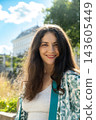 Happy adult female looking at camera with long hair outdoors 143605449
