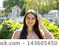 Portrait of attractive 34 year old woman without makeup showcasing natural beauty outdoors 143605450