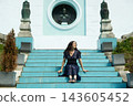 Confident woman sitting on stairs posing with elegance and feminine grace outdoors 143605452