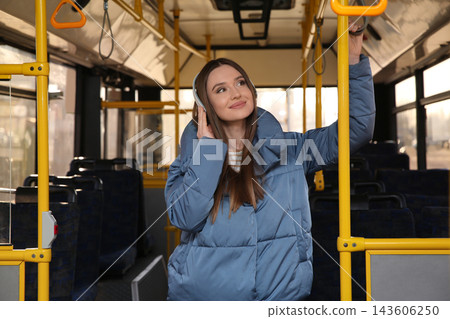 Woman listening to audiobook in trolley bus Woman listening to audiobook in trolley bus 143606250
