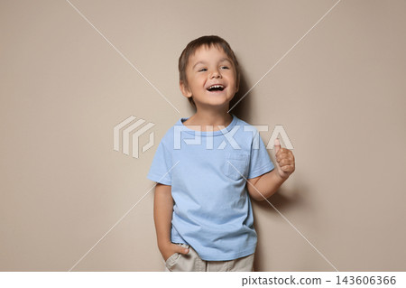 Portrait of cute little boy on beige background Portrait of cute little boy on beige background 143606366