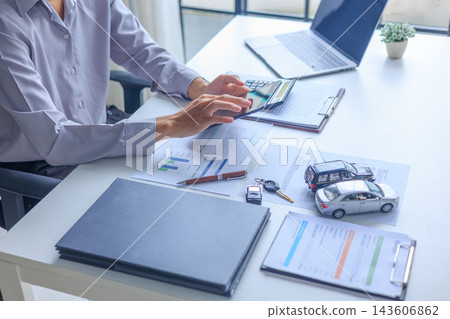 Car loan agent using tablet while reviewing auto insurance policy paperwork at desk Car loan agent using tablet while reviewing auto insurance policy paperwork at desk 143606862