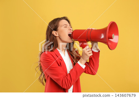 Young woman with megaphone on yellow background Young woman with megaphone on yellow background 143607679