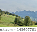 Alpine valley landscape with green hills and wooden barn 143607761