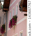Traditional austrian building with pink facade and blooming petunias 143607767