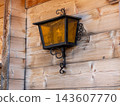 Vintage wrought iron lantern decorating rustic wooden wall 143607770
