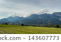 Alpine meadow panorama with rustic barns and mountains 143607773