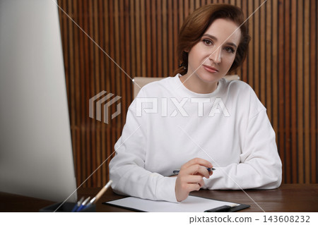 Portrait of psychotherapist at table in office Portrait of psychotherapist at table in office 143608232