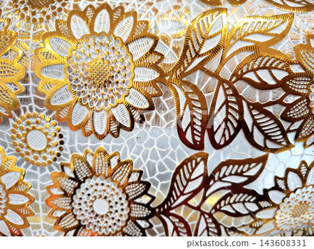 Close up of decorative sunflower motif with golden metallic thread on white lace fabric ideal for luxury home decor textile design and creative backgrounds. Close up of decorative sunflower motif with golden metallic thread on white lace fabric ideal for luxury home decor textile design and creative backgrounds. 143608331