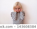 Naughty Little Blonde Girl Covering Ears and Making a Face 143608384