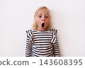 Surprised Little Blonde Girl with Wide Eyes and Open Mouth on White Background 143608395