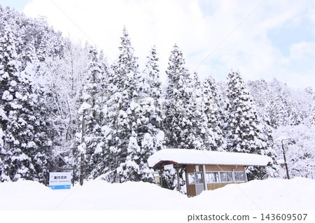 Mimasaka-Kawai Station during a heavy snowfall: the station building buried in snow and the snow-covered cedar forest. Mimasaka-Kawai Station during a heavy snowfall: the station building buried in snow and the snow-covered cedar forest. 143609507