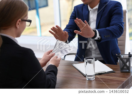 Businessman refuses to take bribe money at wooden table, closeup Businessman refuses to take bribe money at wooden table, closeup 143610032
