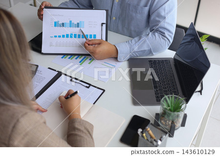 Two Business Colleagues Analyzing Market Trends and Growth Charts During Meeting. Two Business Colleagues Analyzing Market Trends and Growth Charts During Meeting. 143610129