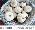 White mini pumpkins in rustic woven basket for autumn festive decor 143610487