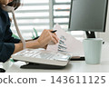 Asian businesswoman working on digital tablet with stylus outside modern building 143611125