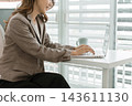 Asian businesswoman working on digital tablet with stylus outside modern building 143611130