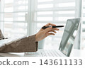 Asian businesswoman working on digital tablet with stylus outside modern building 143611133