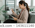 Asian businesswoman working on digital tablet with stylus outside modern building 143611140