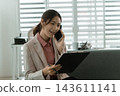 Asian businesswoman working on digital tablet with stylus outside modern building 143611141