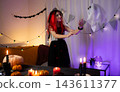 Cute Little Girl In A Halloween Witch Wig Plays With A Ghost In A Decorated Room 143611377