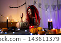 Cute Little Girl In A Halloween Witch Wig Carving A Halloween Pumpkin In A Decorated Room 143611379