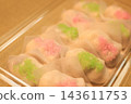 一款包裝簡單卻十分可愛的日本點心，粉紅色和綠色的米粒從斜角拍攝得非常漂亮。 143611753