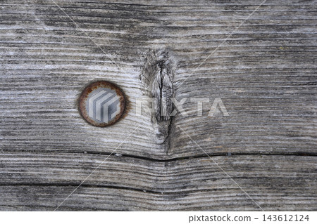 Rusty metal nail head in weathered wooden plank texture Rusty metal nail head in weathered wooden plank texture 143612124