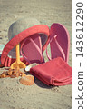Different accessories for relax on sand at beach. Straw hat, slippes, towel. Summer time 143612290