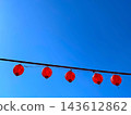 Red Japanese lanterns hanging in a clear blue sky 143612862
