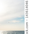 Small airplane flying over open sea beneath expansive pastel sky. Minimalist seascape with abundant sky and copy space. Aviation and travel concept. Freedom, distance and open horizon. 143614046