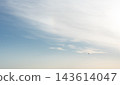 Small airplane flying beneath wispy clouds in open sky. Air travel and aviation concept. Minimalist sky with ample copy space. Calm atmospheric background for travel design. 143614047