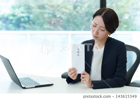 一位神情憂慮的女商人手持辭職信。 一位神情憂慮的女商人手持辭職信。 143615349