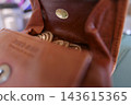 Close-up of a brown leather wallet and a 500 yen coin/small change. 143615365