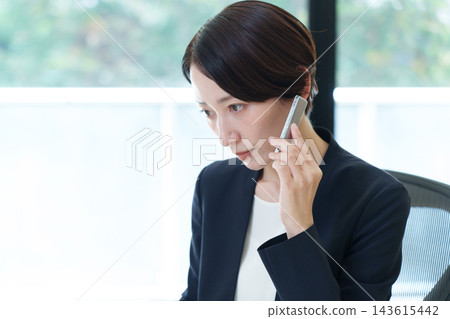 一位女商人正在聽錄音機裡的留言。 一位女商人正在聽錄音機裡的留言。 143615442